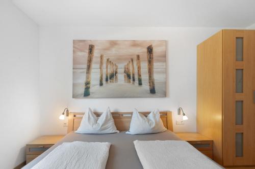a bedroom with two beds and a painting on the wall at Georgshof - Eppan in Appiano sulla Strada del Vino