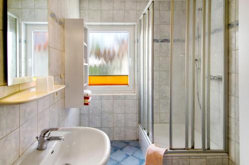 a bathroom with a sink and a shower at Huus Nördernee 1 in Norderney