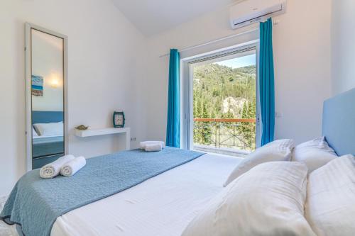a bedroom with a large bed with a large window at Doliva Studio Anthi private jacuzzi in Agios Gordios