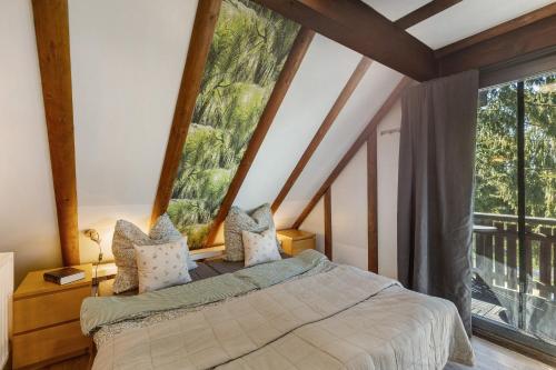 a bedroom with a bed and a large window at Ferienhaus Rotkäppchen in Frankenau