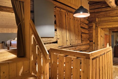 a wooden staircase in a log cabin with a light at Berghaus Wiesegg - Uriges Tiroler in Fügenberg