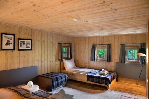 a room with two beds in a wooden room at Berghaus Wiesegg - Uriges Tiroler in Fügenberg