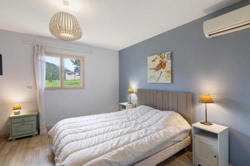 a bedroom with a large bed and a window at La Cense De La Mérelie - Le Logis in Saint-Geniès