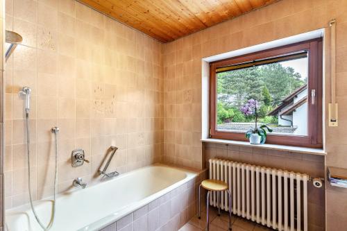 a bathroom with a bath tub and a window at Marlene in Friesenheim