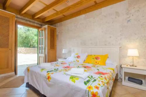 a bedroom with a large white bed with flowers on it at Sa Sargantana in Islas Baleares