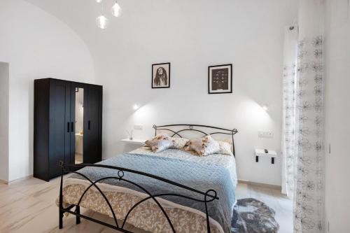 two dogs laying on a bed in a white bedroom at Silvana's House in Agerola