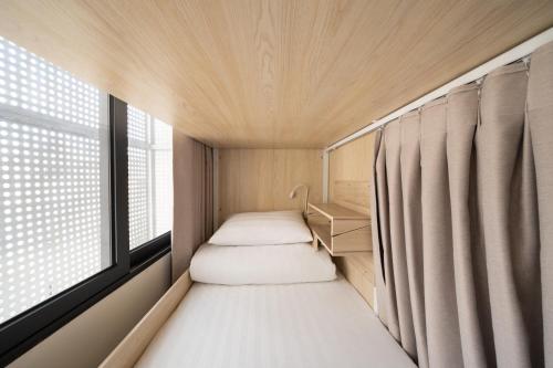 a small room with two beds and a window at 2Re Hidden Hostel 58 Hàng Bạc in Hanoi