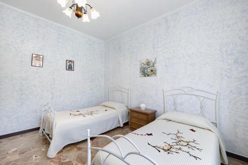 two beds in a room with blue walls at Casa Grace - Casa al Mare in Vado Ligure