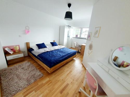 a bedroom with a bed with blue sheets and a mirror at Luxury Villa Vienna in Mauerbach