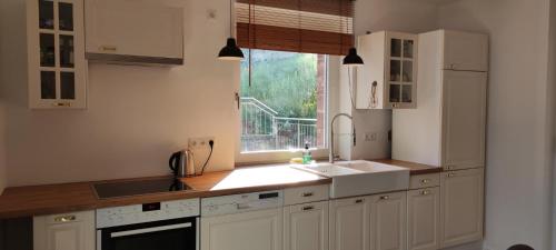 a kitchen with white cabinets and a sink and a window at Ferienwohnung Die Raspel in Melsungen
