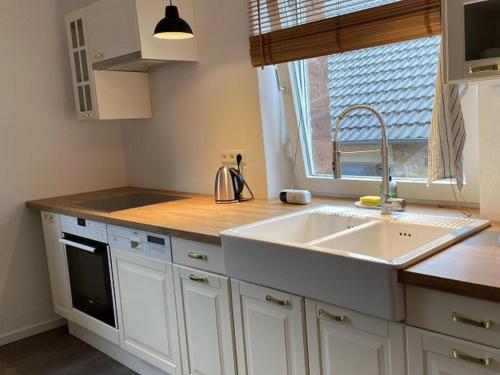 a white kitchen with a sink and a window at Ferienwohnung Die Raspel in Melsungen