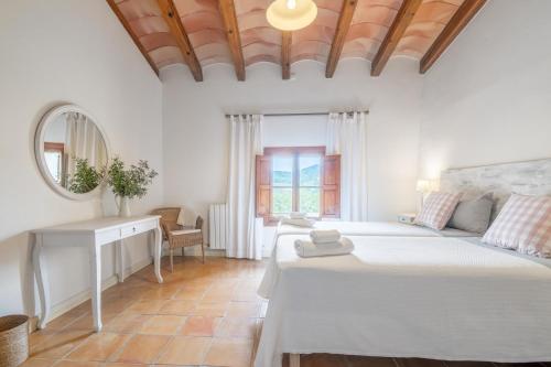 a bedroom with a bed and a desk and a mirror at Agroturismo Son Bauzanet in Palma de Mallorca