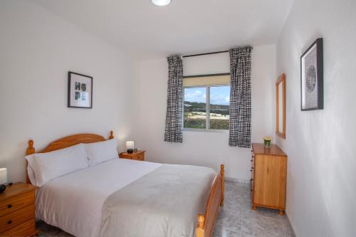 a bedroom with a white bed and a window at Hacienda Los Adejo in Moya