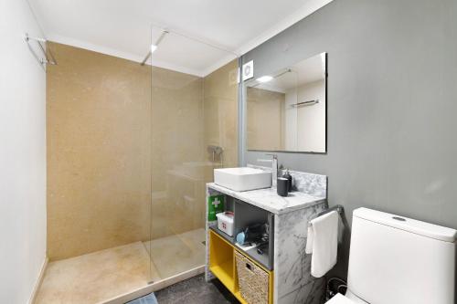 a bathroom with a sink and a toilet and a mirror at Estoril Art and Surf in Estoril