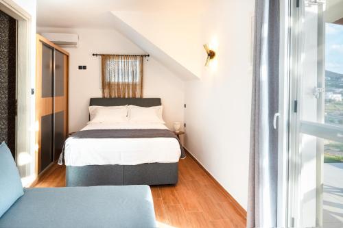 a small bedroom with a bed and a window at Mont' Rock villas 3 in Posidhonía