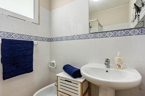 a white bathroom with a sink and a mirror at Formosa Beach in Porto Santo