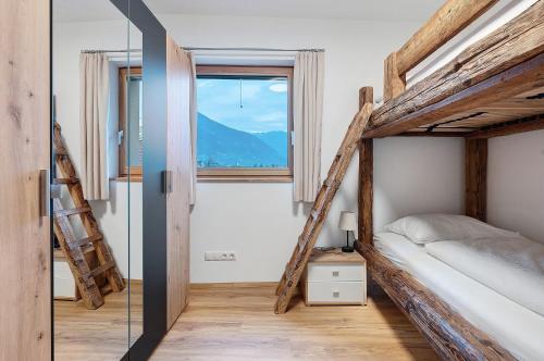 a bedroom with two bunk beds and a window at Matscherhof Lana in Lana