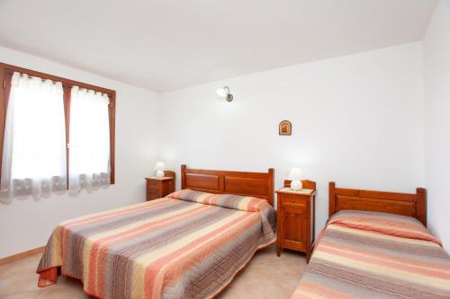 a bedroom with two beds and a window at Appartamento Melissa a Orosei in Orosei