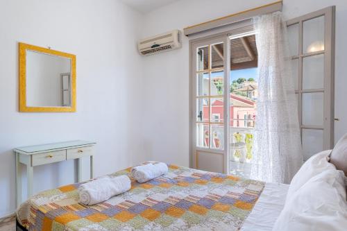 a bedroom with a bed and a large window at Kassiopi Apartment 2 in Kassiopi
