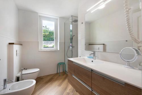 a bathroom with a sink and a toilet and a mirror at Villa Angelina in Lavagna