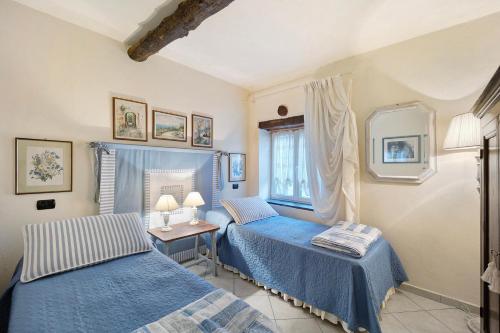 ein Schlafzimmer mit zwei Betten und einem Tisch mit Spiegel in der Unterkunft Casa dei Tigli in Ormea