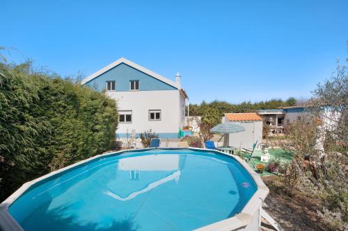 a large swimming pool in front of a house at Quinta das Andorinhas - Nazaré in Famalicão