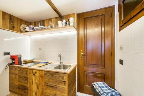 a kitchen with a sink and a wooden door at Il Nido di Letizia in Châtillon