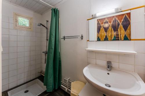a bathroom with a sink and a green shower curtain at Villa Eva in Biscarrosse-Plage