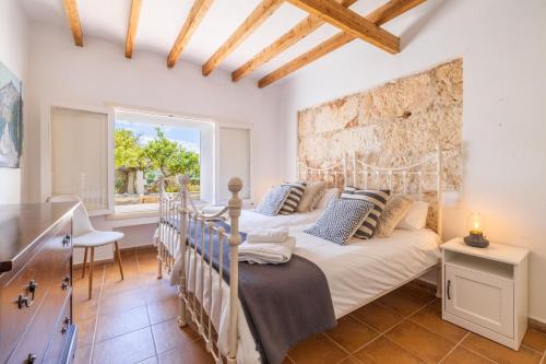 a bedroom with two beds and a window at Casa de los Almendros in El Port de la Selva
