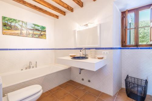 a bathroom with a sink and a tub and a toilet at Casa de los Almendros in El Port de la Selva