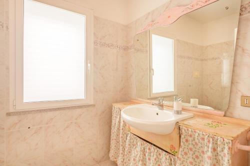 a bathroom with a sink and a mirror at Villa Alfredo Golfo Aranci in Golfo Aranci