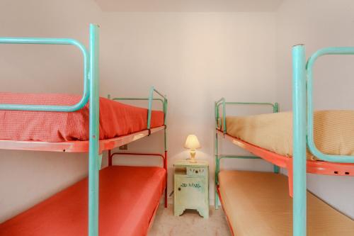 two bunk beds in a room with a lamp on a table at Villa Alfredo Golfo Aranci in Golfo Aranci