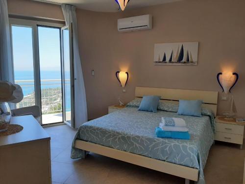 a bedroom with a bed with a view of the ocean at Villa Bella Vista in Zambrone