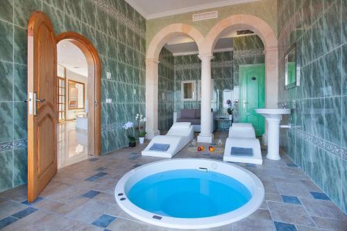 a large bathroom with a large tub in a room at Villa Juan Carlos in Cala Vinyes