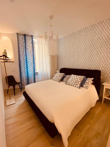a bedroom with a large white bed and a chandelier at A Vernazza La Conchiglia Doro in Vernazza
