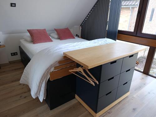 a bedroom with a bed with a wooden desk at " Al'Coppette " Gîte open-space in Comblain-au-Pont