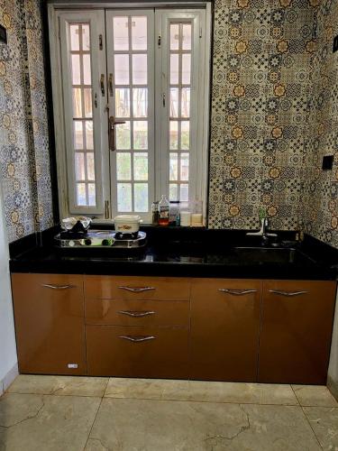 a kitchen with a black counter and a sink at Twilight Stays ll 2 Bed Villa ll Swimming Pool ll AC ll BBQ in Lonavala
