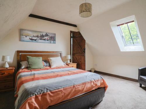 a bedroom with a large bed and a window at Cider Cottage - near Lyme Regis in Axminster