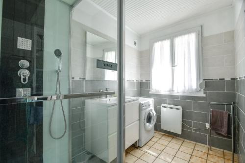 a bathroom with a washing machine and a shower at Gite Les Salicornes in Lanchères