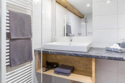 a white bathroom with a sink and a mirror at Appartement Moosmann in Mellau