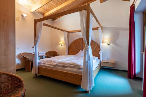 a bedroom with a canopy bed in a room at Sabina Dolomites Lärche in Alpe di Siusi