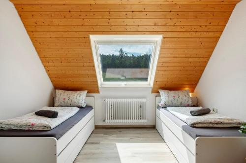 two beds in a room with a window at Ferienwohnung Ringwald in Niederbach