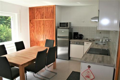 a kitchen with a table and chairs in a kitchen at Haus am Waldrand in Triberg