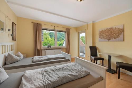 a bedroom with two beds and a desk and a chair at Ferienwohnungen Golsong in Thaleischweiler-Fröschen