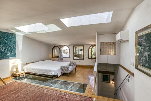 an attic bedroom with a bed and a skylight at Designer House With Panoramic views in Cadaqués