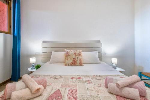 a bedroom with a large white bed with two lamps at Endless Summer Apartment in Isola Rossa