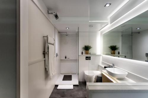 a white bathroom with two sinks and a mirror at Bayview 203 in Hermanus