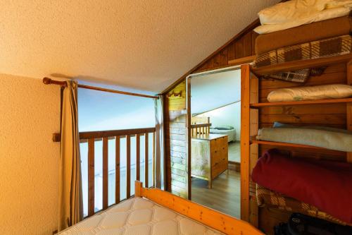 a room with a balcony with a bunk bed at Appartement Manigod Merdassier 8 p in Manigod
