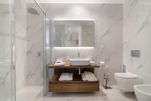 a bathroom with a sink and a toilet and a shower at Mare Nostrum in Olhão