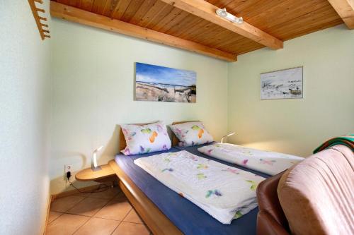 a bedroom with a bed and a couch at Apartment Eulenhof 1 in Bordelum